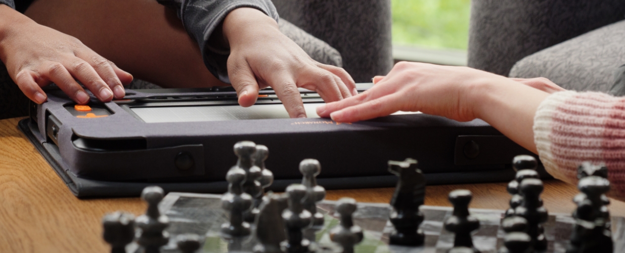 Two people playing chess with the Monarch